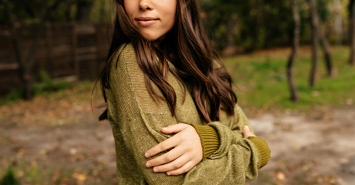 a girl showing how to style a green sweater for winter