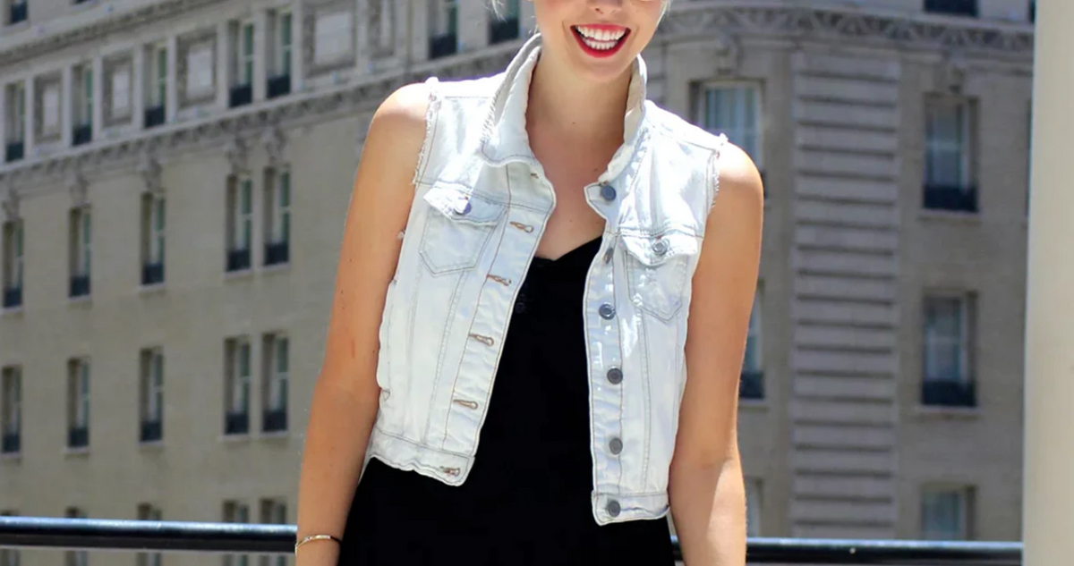 A model wearing a denim vest with a black dress in a chic style