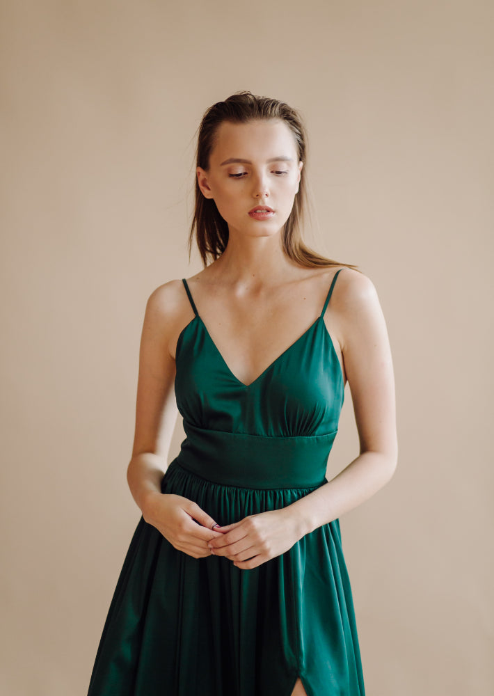 a young woman showing how to wear a green dress in a chic style