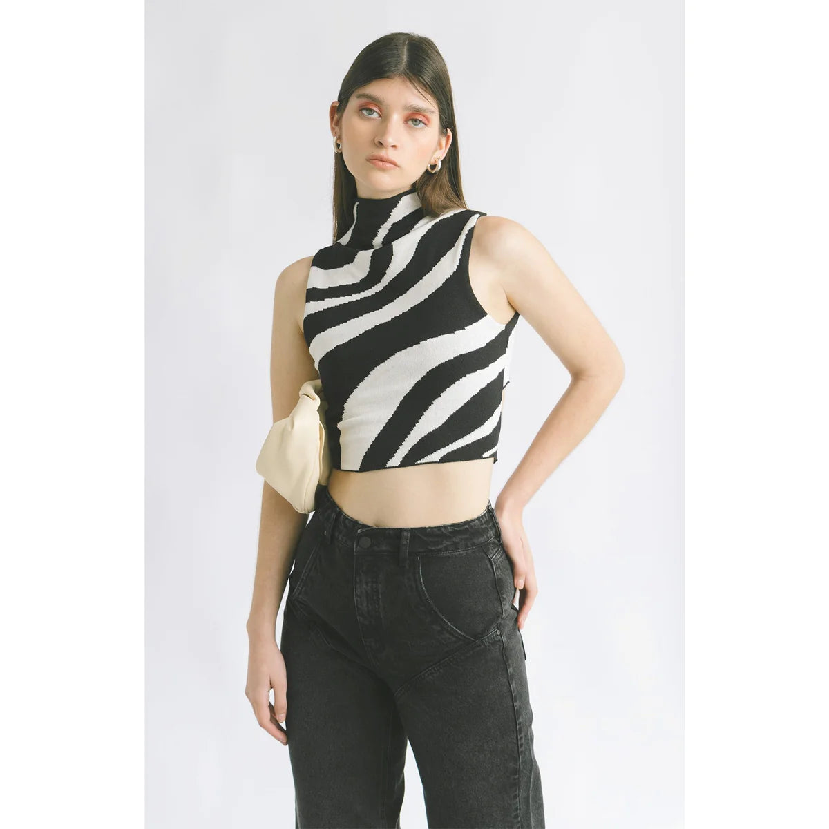 a model styling black jeans with a zebra top and a white handbag in the OnPost style