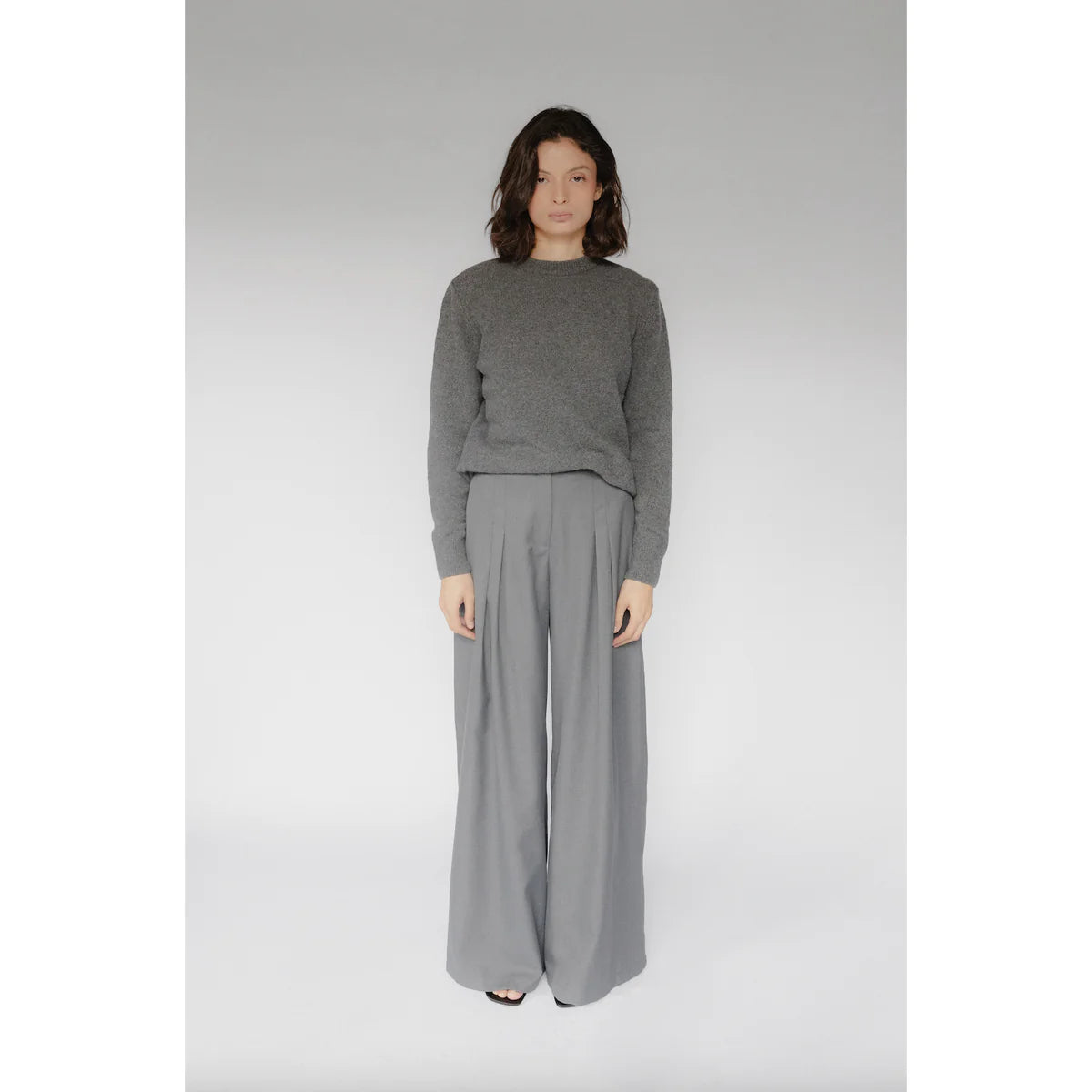 a model showing us how to style chic tomboy with monochromatic gray palette wide pants and knitted sweater in OnPost