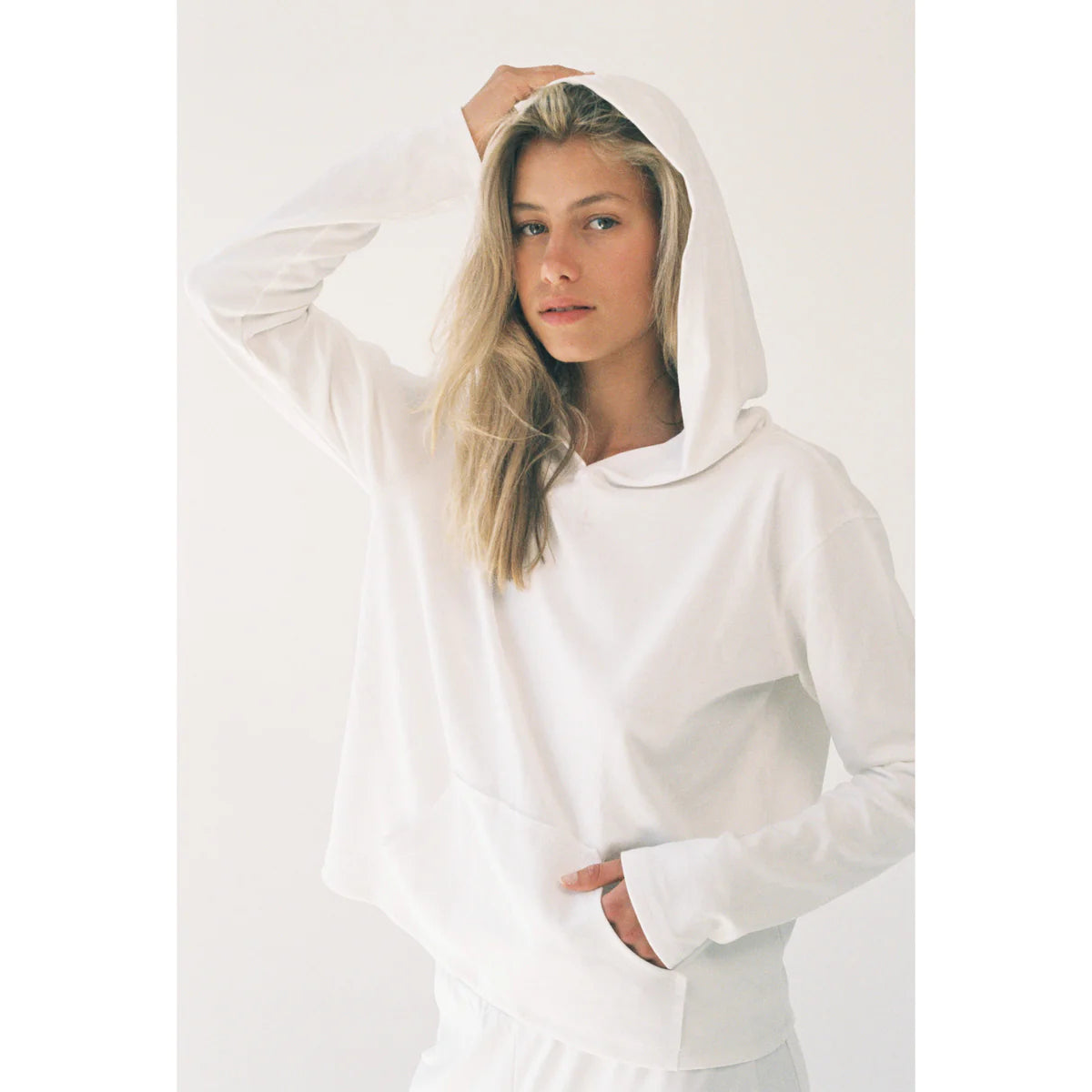 a model showing us how to style a hoodie that is white without looking mid by OnPost