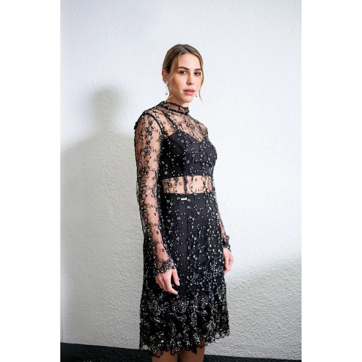 A model with a glam style showing what to wear for a night out using a black dress