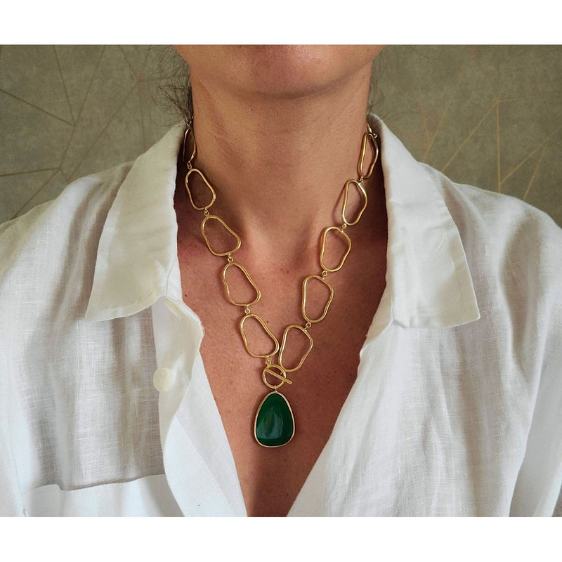 Sleek and contemporary gold/green necklace with a unique pendant, making a statement in modern fashion.